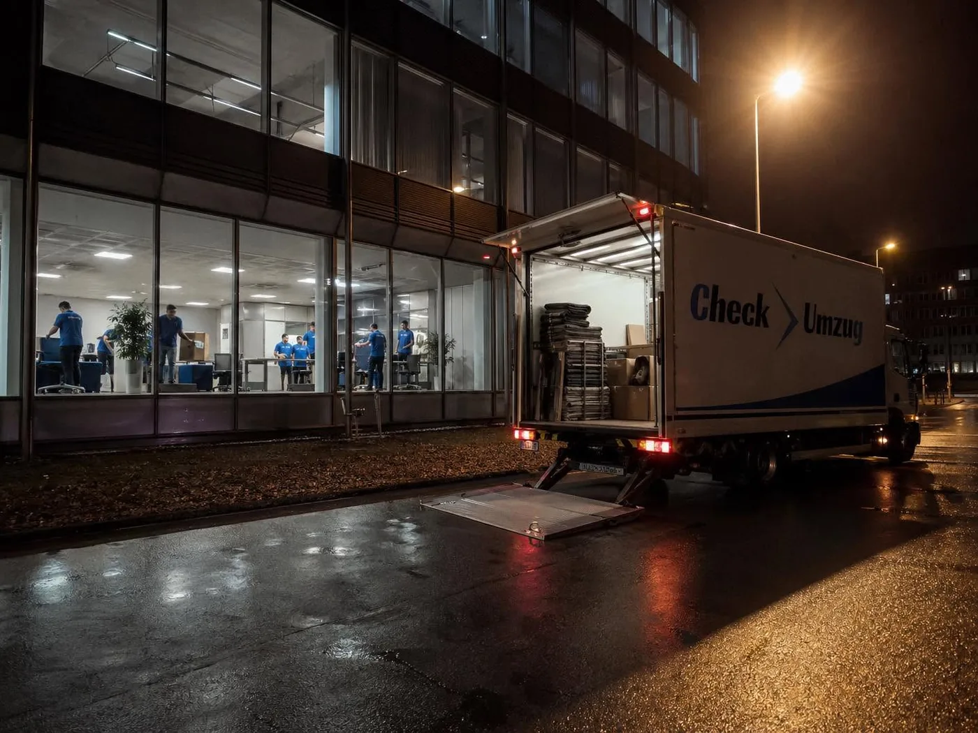 Check Umzug Team beim Firmenumzug – Beladen des Transporters am Bürogebäude